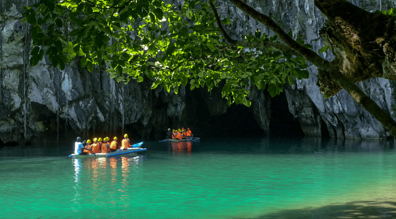 boats going inside the puerto princesa underground river tour with tourists in palawan philippines